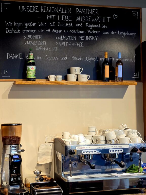 Kaffeeecke im Café Coucou in Weilheim. Auf der Tafel sind regionale Partner aufgelistet, wo Echter ihre Lebensmitel bezieht