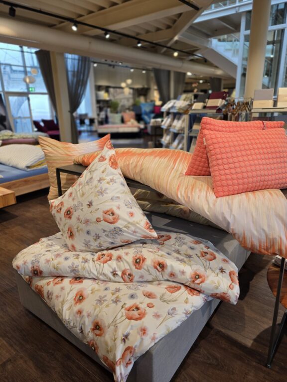 Florale Bettwäsche in Orange und Rosa, dekorativ präsentiert in der Wohnwelt von Echter Wohnen in Murnau