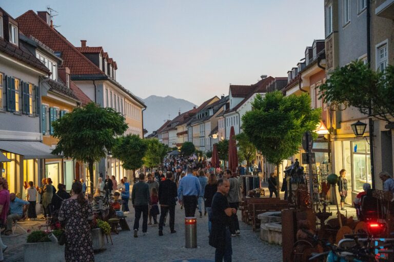 Menschen flanieren bei der Kunstnacht Murnau 2025 in der abendlichen Innenstadt von Murnau.