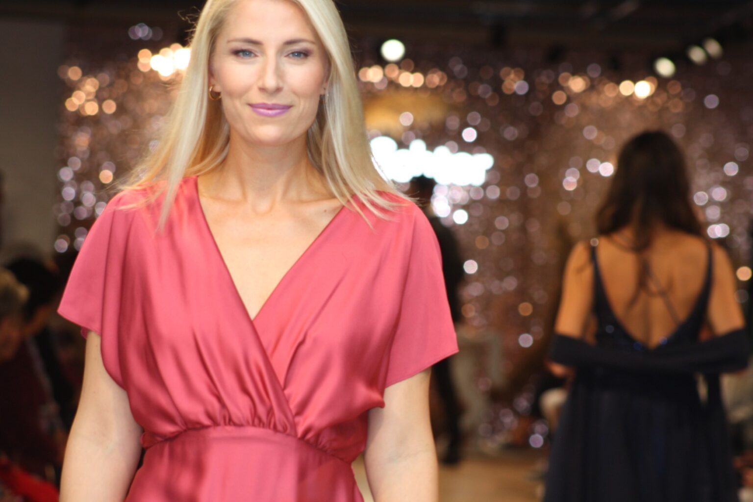Model in elegantem pinkfarbenem Kleid auf dem Laufsteg bei der Großen Echter Modenschau im Kultur- und Tagungszentrum Murnau