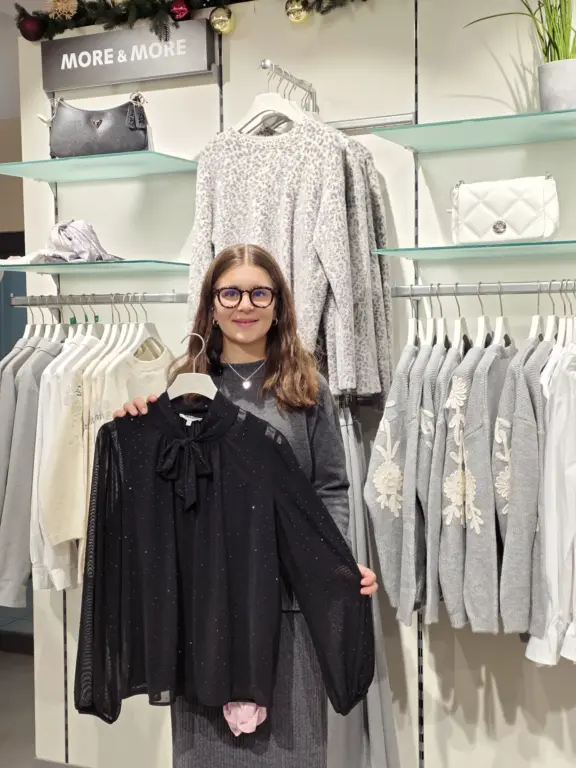 Hanna aus Mittenwald präsentiert eine schwarze, transparente Bluse mit Glitzerpunkten von More & More.