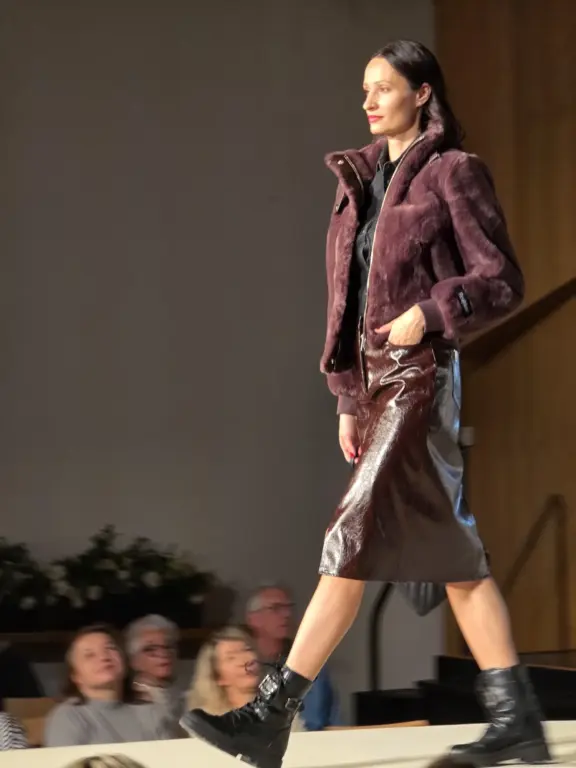 Model in bordeaux Jacke und bordeaux Lederrock bei der Großen Echter Modenschau 2025 in Murnau.