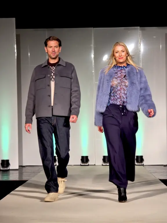 Männliches und weibliches Model in farblich abgestimmten Herbstoutfits auf dem Laufsteg in KTM Murnau am 2.10.2025.