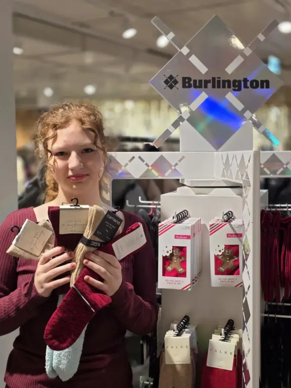 Lena aus Oberammergau hält verschiedene kuschlige Winter- und Wollsocken mehrerer Marken.