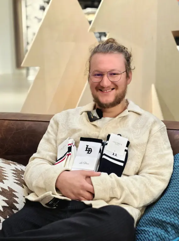 Lukas aus Garmisch-Partenkirchen sitzt entspannt und zeigt mehrere Paar Les Deux Socken in cleanem Design.