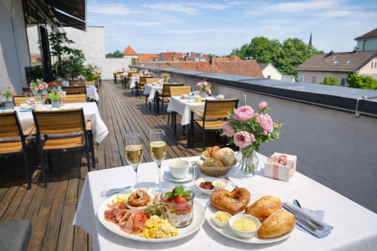 Muttertagsbrunch im Café Coucou in Weilheim mit liebevoll gedecktem Tisch, Frühstücksauswahl und Prosecco in stilvoller Atmosphäre.