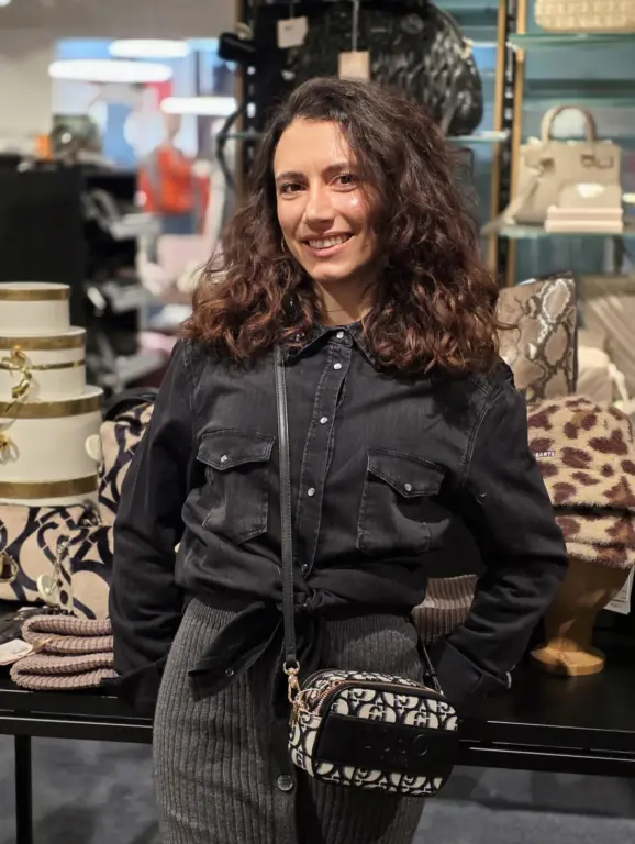 Roxana aus Geretsried trägt ein schwarzes Denim-Hemd und eine gemusterte LIU JO Crossbody Bag.