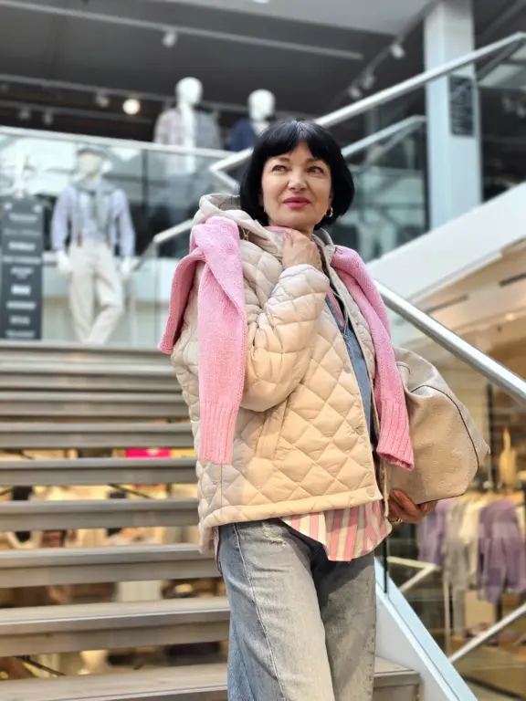 Model präsentiert Frühlingslook mit Steppjacke, Jeans und rosa Strick im Modehaus Echter Murnau