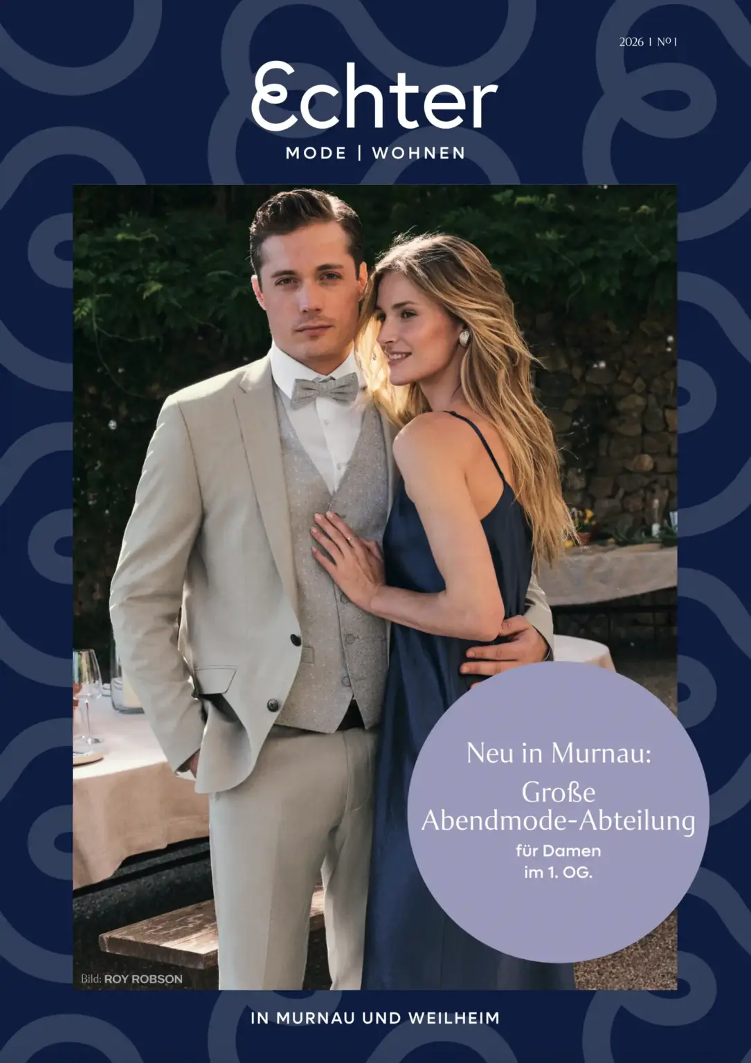 Paar in eleganter Abendmode, Herr im hellen Anzug, Dame im dunkelblauen Kleid – Werbung für neue Abendmode-Abteilung in Murnau im Modehaus Echter.