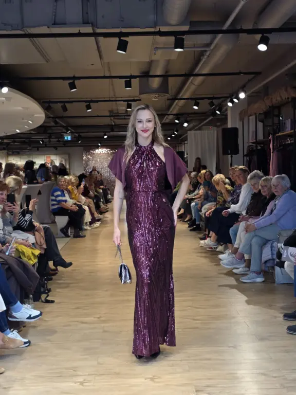 Model in bordeauxroter Abendrobe auf dem Laufstegbei der Großen Echter Modenschau in Weilheim am 27.09.2025